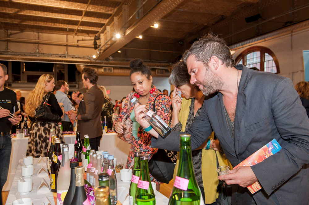 jos14ny009 A man holding and studying a bottle (2014 New York)