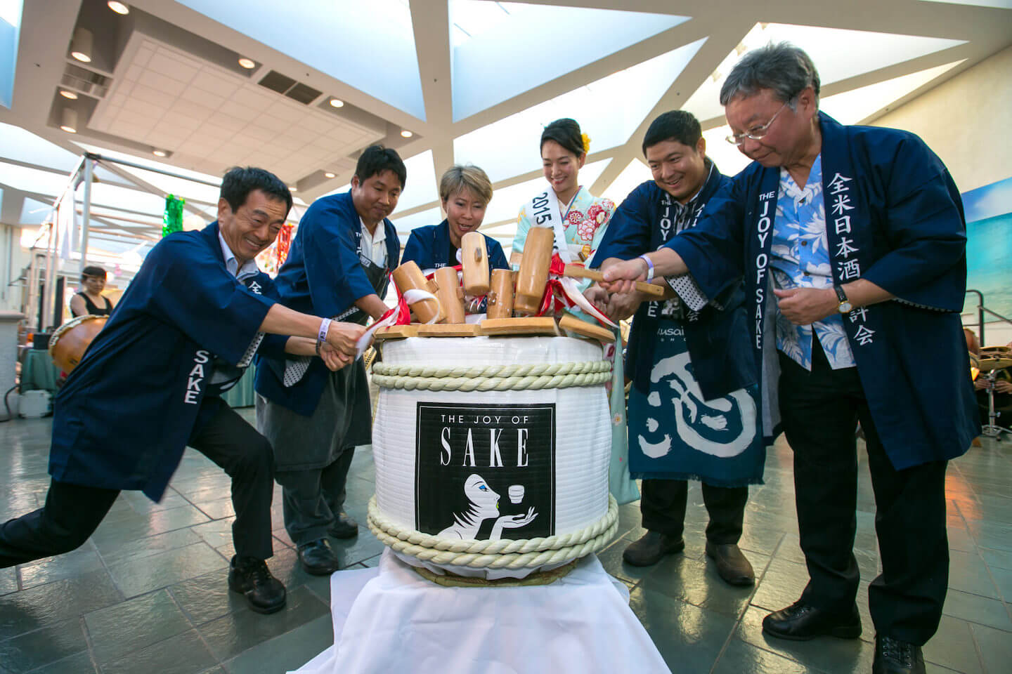 Brewers, Miss Sake and others opening a sake barrel with wooden mallets (2015 Honolulu)