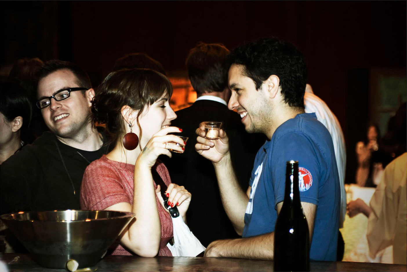 A happy couple facing each other enjoying sake with photo bomb (2008 New York)
