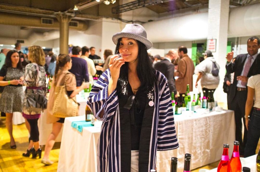 jos13ny004 A smiling lady with happi and fedora holding a sake cup and posing (2013 New York)