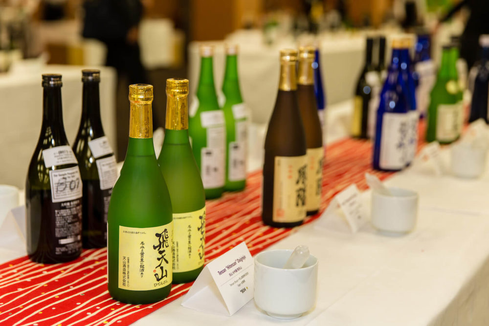 jos16tk002 Pairs of bottles lined up on red and white table runners (2016 Tokyo)
