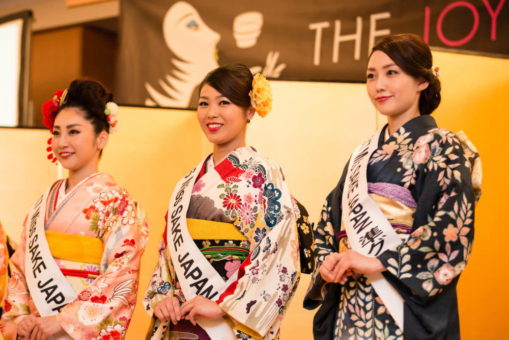 jos17tk035 Three winners of Miss Sake 2018 in kimono standing in front of golden byobu (2017 Tokyo)
