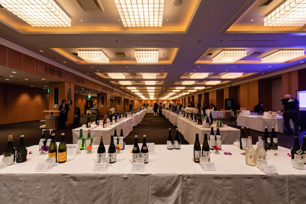 jos18tk111 A view of the ballroom from one end to the other with tables and bottle displayed before the event (2018 Tokyo)