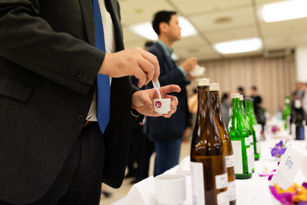 jos18tk242 A man pouring sake into his cup using pippett at the table (2018 Tokyo)