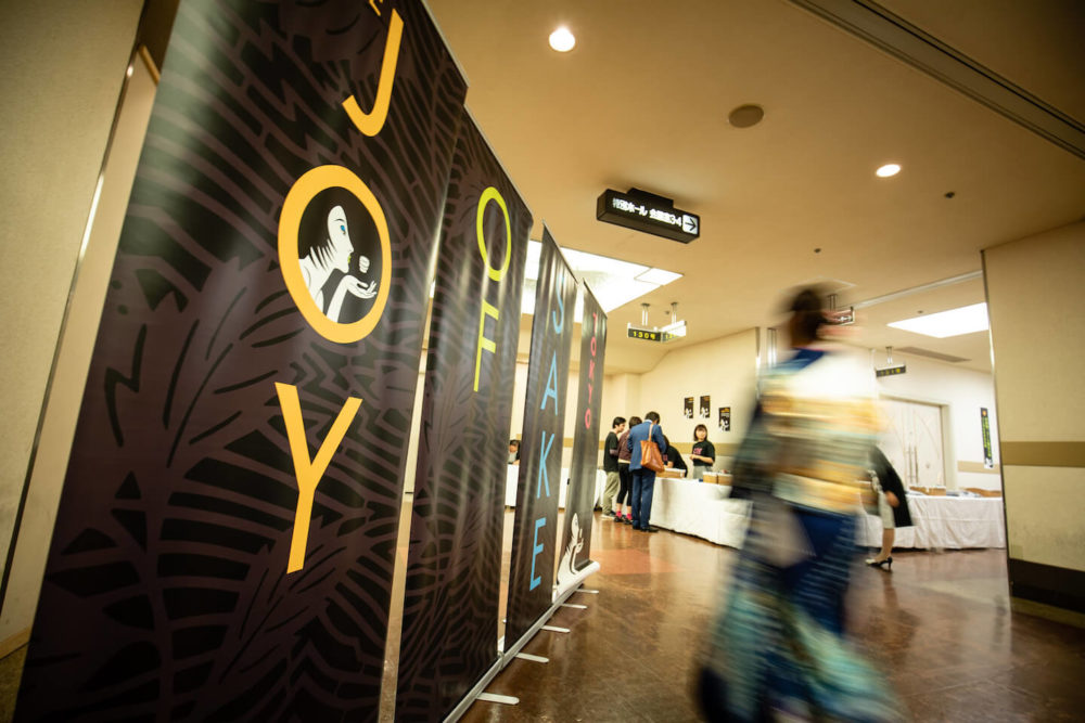 jos19tk008 Four pannels of Joy of Sake banner with motion blured kimono lady passing by (2019 Tokyo)